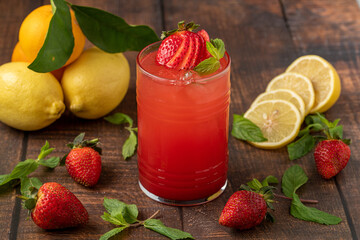 Iced strawberry lemonade in glass glass on wooden table