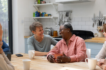 Group of multi generational women gathering socially with a hot drink