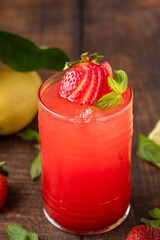 Iced strawberry lemonade in glass glass on wooden table