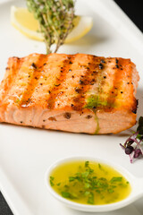 Appetizing grilled salmon fillet on a white plate.