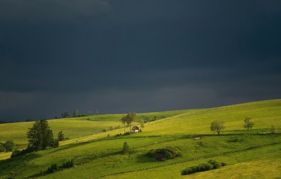 Spring photo of the rural mountainous landscape in Kacwin at the foot of the Tatra Mountains, small chapel on the green fields, oncoming storm, storm clouds. Poland, Polska