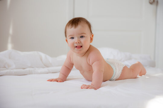 Portrait of a crawling baby on the bed in her room,happy baby on a bed at home