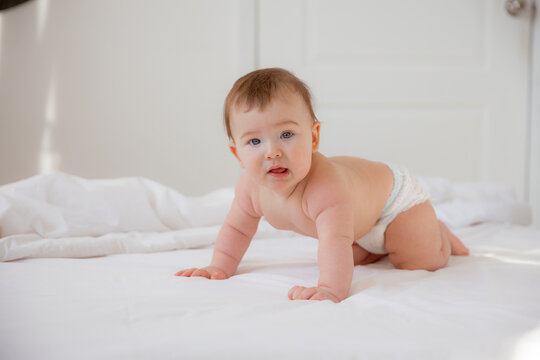 Portrait of a crawling baby on the bed in her room,happy baby on a bed at home