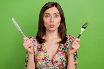 Portrait of cute lady pouted lips kiss hands hold knife fork isolated on green color background