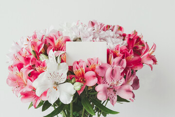 Bright beautiful bouquet of alstroemerias and chrysanthemums on a white background with an empty...
