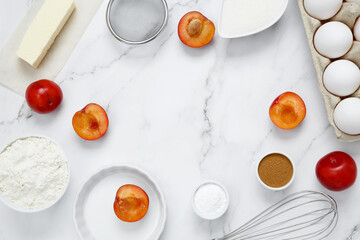 Ingredients for making classic cake pie with plums on white background. Concept homemade food, seasonal pastries. Top view, copy space