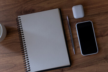notebook and pen with phone and pods