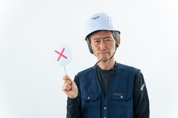 ばつ印を見せる職人