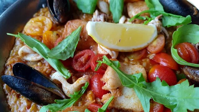 Paella seafood Spanish food rice baked with mussle squid fish and shrimp topping with tomato and lemon