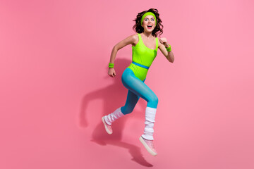 Photo of excited lady coach racing on marathon in jump winning isolated over pastel color background