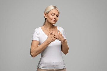 Heart Attack. Mature blonde woman suffering from severe chest pain
