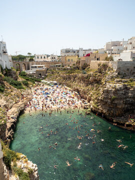 cala llena de gente en verano un di+&iacute;a caluroso y soleado con el mar turquesa