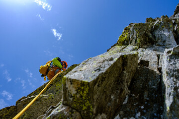 Alpinista scende da una parete in corda doppia
