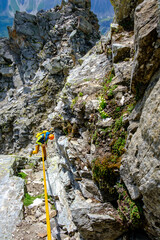 Alpinista scende da una parete di roccia in corda doppia, Alpi Svizzere, Pizzo Nero