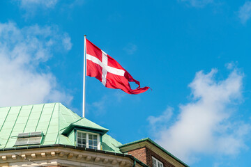 Danish flag on an old building in the city center in Copenhagen, Denmark