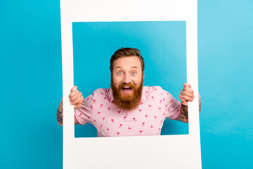Portrait of impressed overjoyed person hands hold paper album set card window isolated on blue...