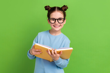Portrait of toothy beaming girl with brown hair wear blue sweatshirt in glasses hold book do...