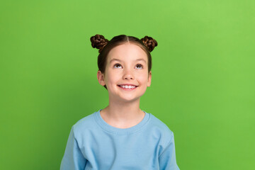 Photo portrait of funny small girl wear blue casual shirt look up empty space interested isolated...