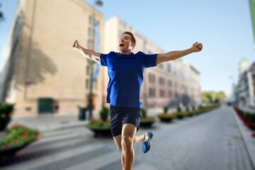 Fototapeta na wymiar Cheerful and successful sporty man jogging outdoor