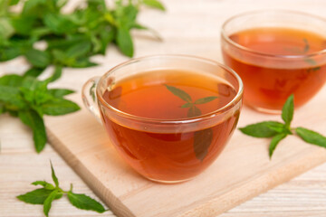 Cup of mint tea on table background. Green tea with fresh mint top view with copy space