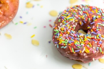 chocolate doughnut with sprinkles and confetti on a white plate