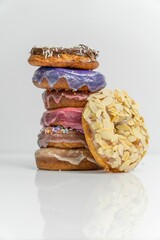 several doughnuts are stacked up with frosting and toppings