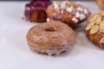 a variety of donuts sitting next to each other on a white table