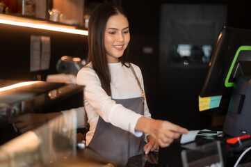 A young woman cashier working in modern coffee shop