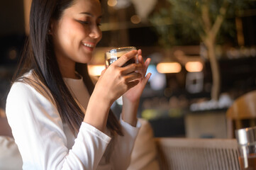 A young woman drinking coffee in modern coffee shop