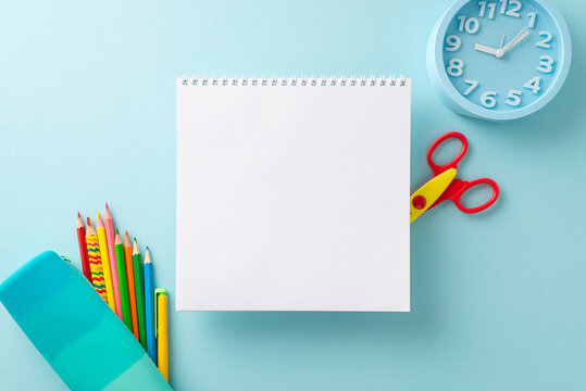 Communicate the essence of education effectively with this top view picture of notepad and stationery on pastel blue isolated background. Suitable for educational marketing and copy placement