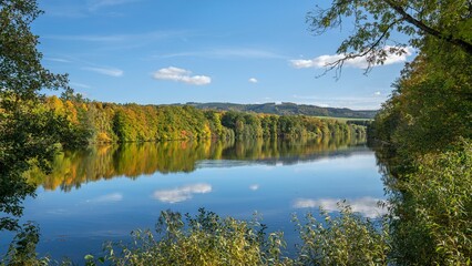 Tranquil Henne Lake surrounded by vibrant foliage in Sauerland, Germany