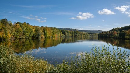 Tranquil Henne Lake surrounded by vibrant foliage in Sauerland, Germany