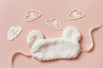 Sleeping mask from light fur and clouds shape with z snore sounds on pink background. Fluffy eye...