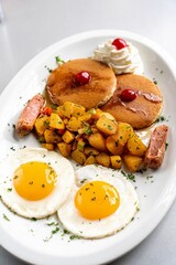 Appetizing and diverse Dominican-American breakfast plate consisting of scrambled eggs, pancakes