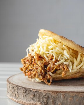 Vertical closeup of Venezuelan dish of carne mechada in arepa