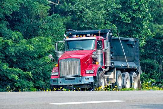 Heavy-Duty Red Dump Truck Merging Onto Main Road