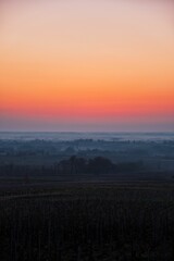 Sunset over the rural field in the mist ,vertical shot