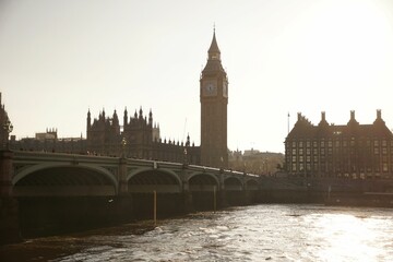 big ben towering over a river and city at sunset in london