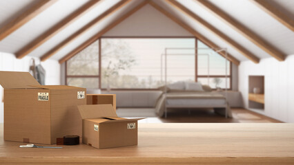 Wooden table, desk or shelf with stack of cardboard boxes over blurred view of penthouse japandi bedroom in minimal style, interior design, moving house concept with copy space