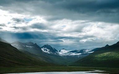 a lake in the middle of a field in the mountains