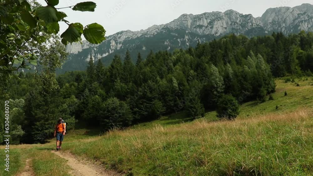 Canvas Prints Man hiking rocky peak of Piatra Craiului Mountains range under a blue sunny sky