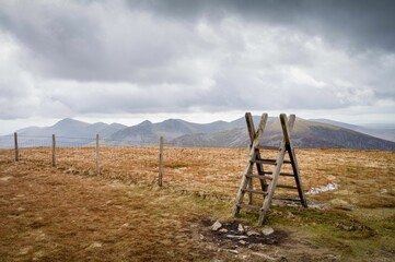 Wooden ladder in the Nantlle range of mountains from Moel Eilio in Eryri against a clouded sky