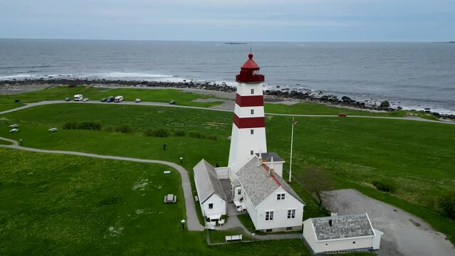 4K drone video of the wooden, white and red Alnes Fyr, light house on Godoya Island, Aalesund.