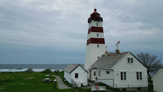 4K drone video of the wooden, white and red Alnes Fyr, light house on Godoya Island, Aalesund.