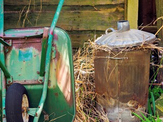 Old wheel barrow and fire bin in the garden