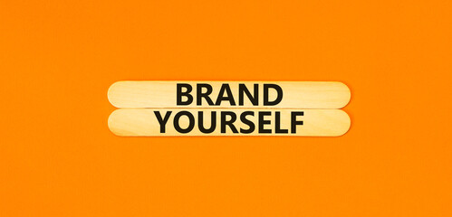 Brand yourself symbol. Concept words Brand yourself on beautiful wooden stick. Beautiful orange table orange background. Business brand yourself concept. Copy space.