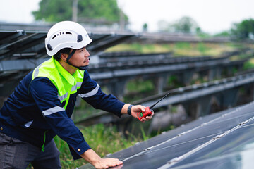 Asian engineer working in solar power plant. Solar panel background. Photovoltaic module idea for...