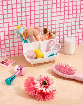 Facial cosmetic products and decorative cosmetic. Makeup products. Pink comb for hair care, scissors for manicure or pedicure, facial brush and facial massagers.