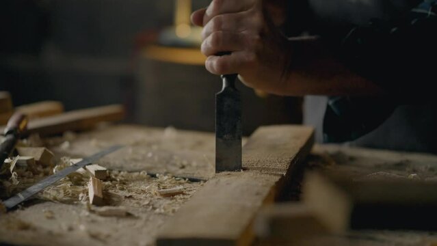 Whiteboard, Small business owners Working with a chisel knocking chips out of wood working with a tool In a production room. Furniture assembly worker Spends working time exploring new ideas At work