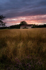 Fototapeta na wymiar old stone barn during sunset over field